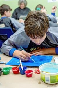 Un élève concentré à peinturer son oeuvre